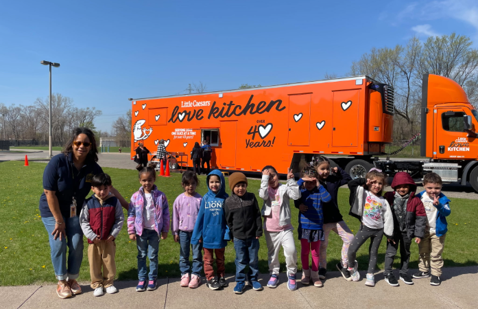  preschool students and a teacher in front of the food truck 